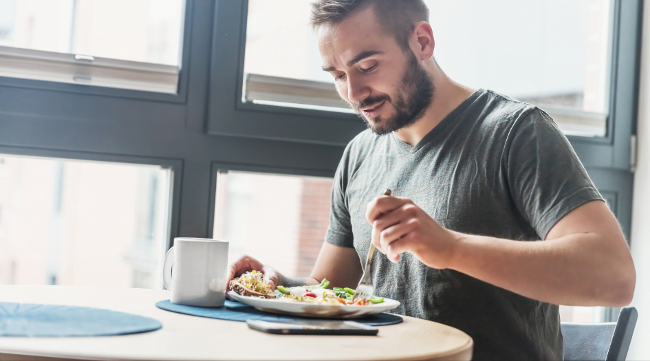 A man relishes a hearty meal rich in vegetables, highlighting the positive impact of lifestyle changes on erectile dysfunction.  The image underscores the essence of embracing erectile dysfunction and lifestyle changes as a transformative pathway to enhanced sexual well-being.
