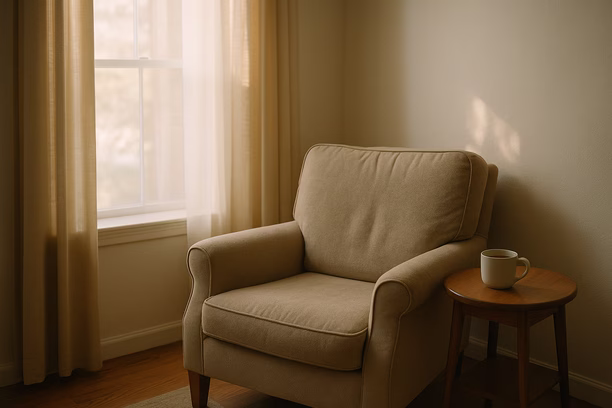 alt_text: A cozy living room corner with morning light, featuring an armchair and a tea-filled side table.